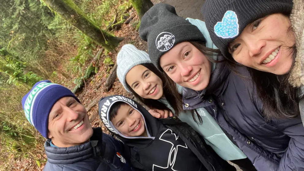 Stroke survivor Adrienne Martin with her husband and three children in a forest.