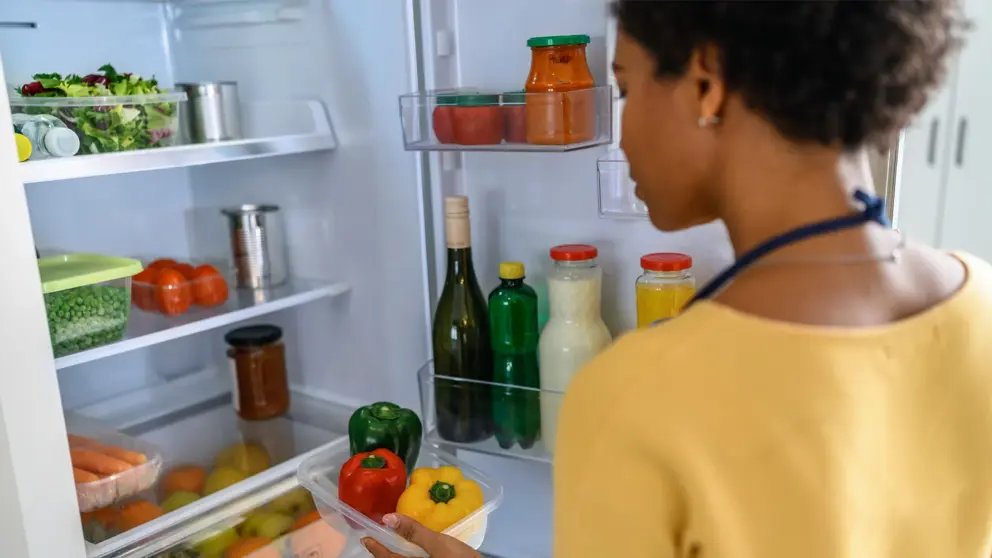 Woman looking at food in refrigerator