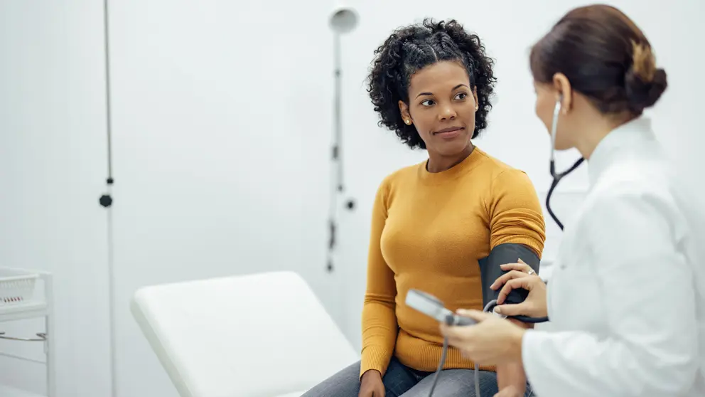 A healthcare professional checks a patient’s blood pressure