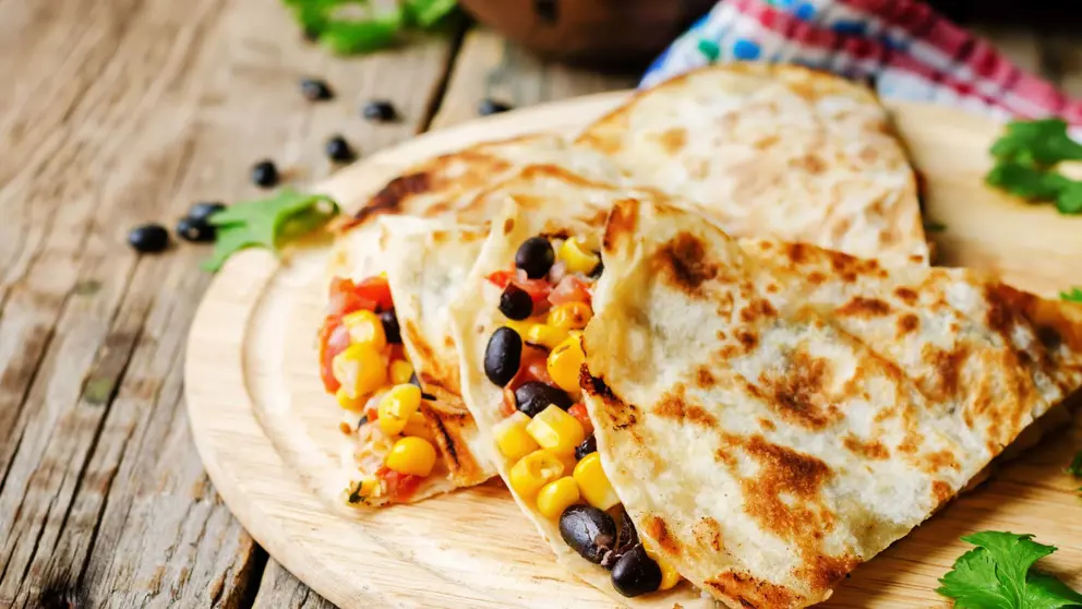 Quesadillas on a wooden dish.