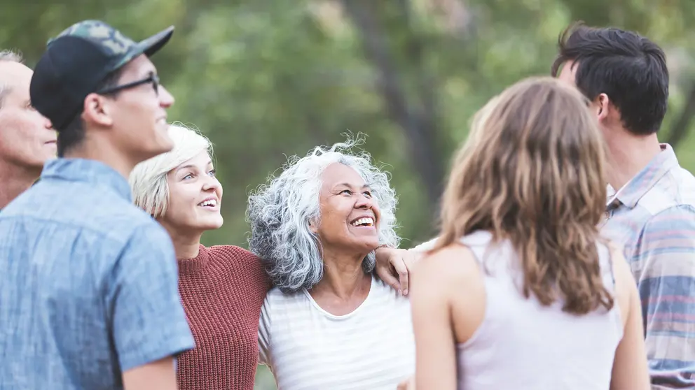 Smiling group of people talking together outdoors