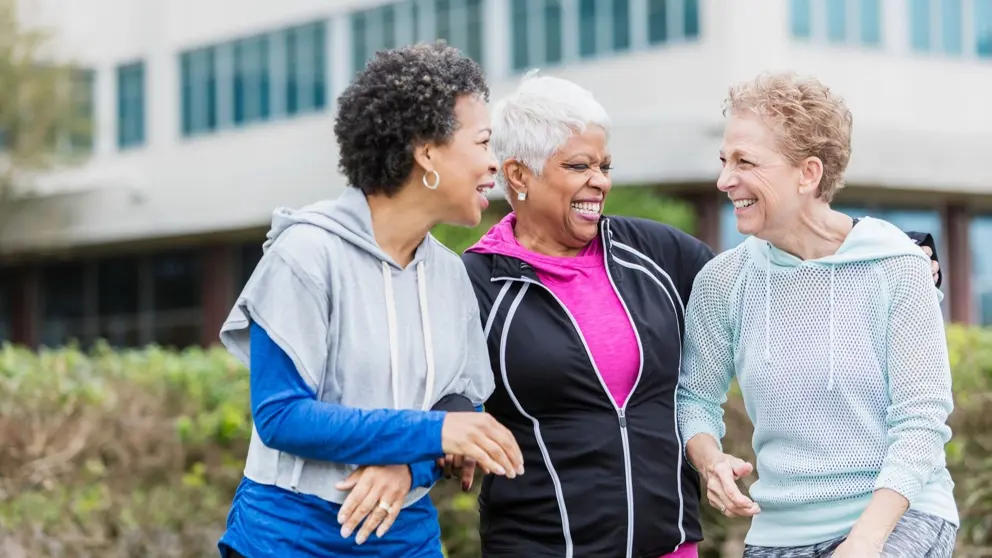 three women laughing in workout clothes.