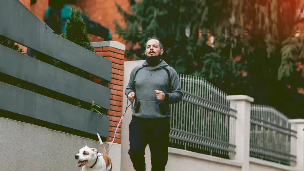 Man jogging outside with his dog 