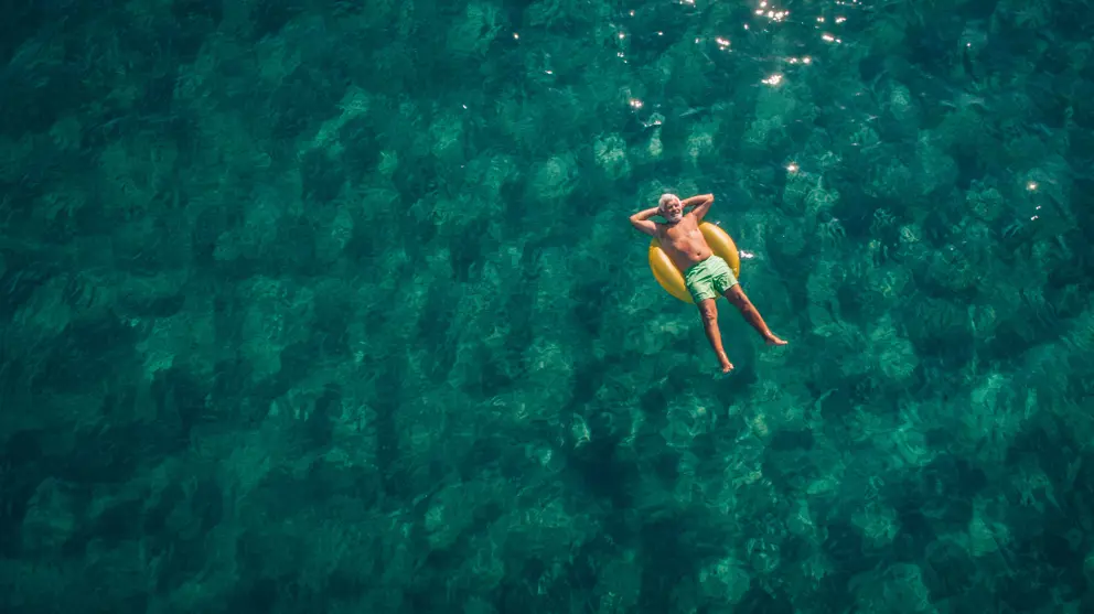 Man laying back on swimming ring in the sea 