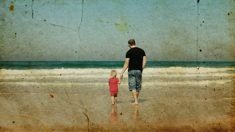 Vintage photo of daughter and father holding hands walking on beach