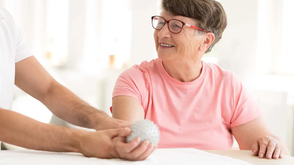 A smiling woman being treated by a doctor.