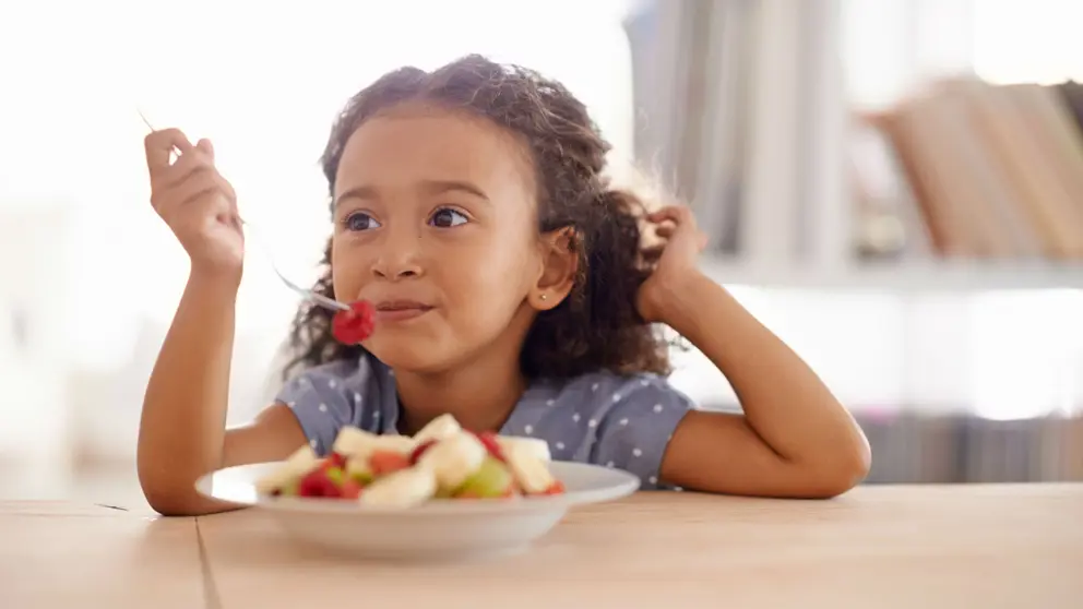 Girl eating fruit salad