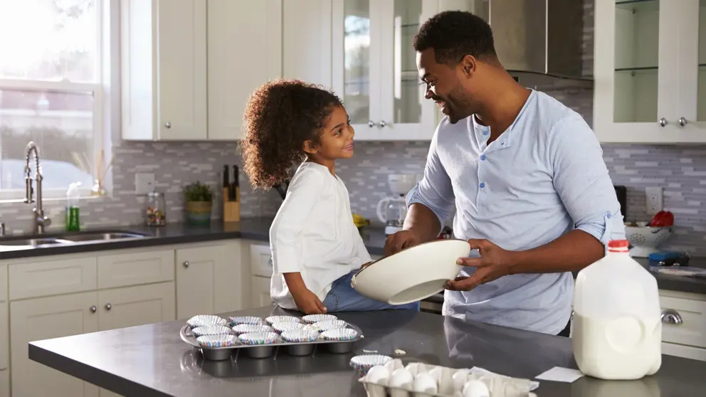 Father and daughter baking in kitchen