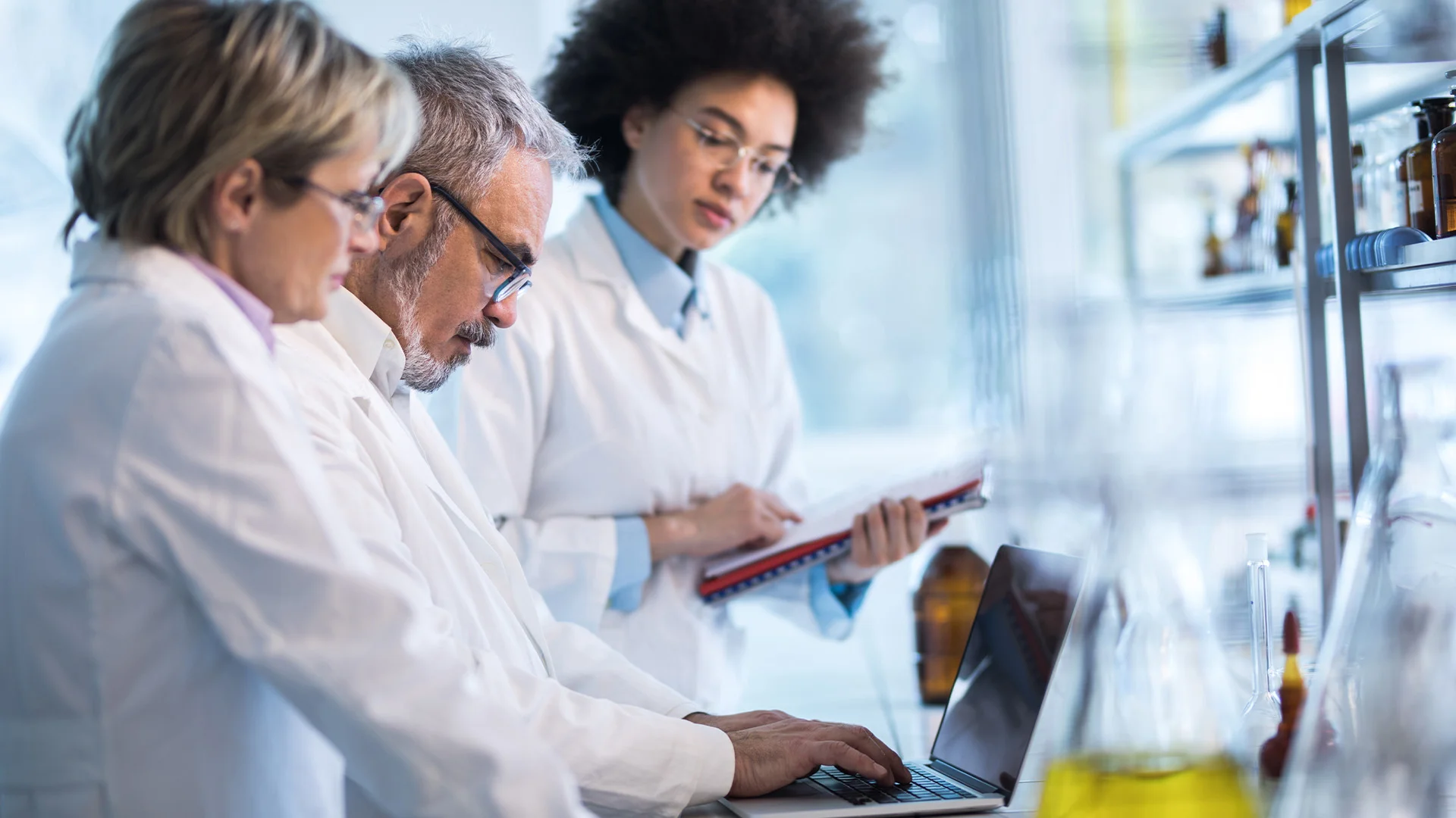 Three researchers using a computer in a lab.