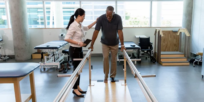 A physiotherapist assists a patient during rehabilitation exercise.