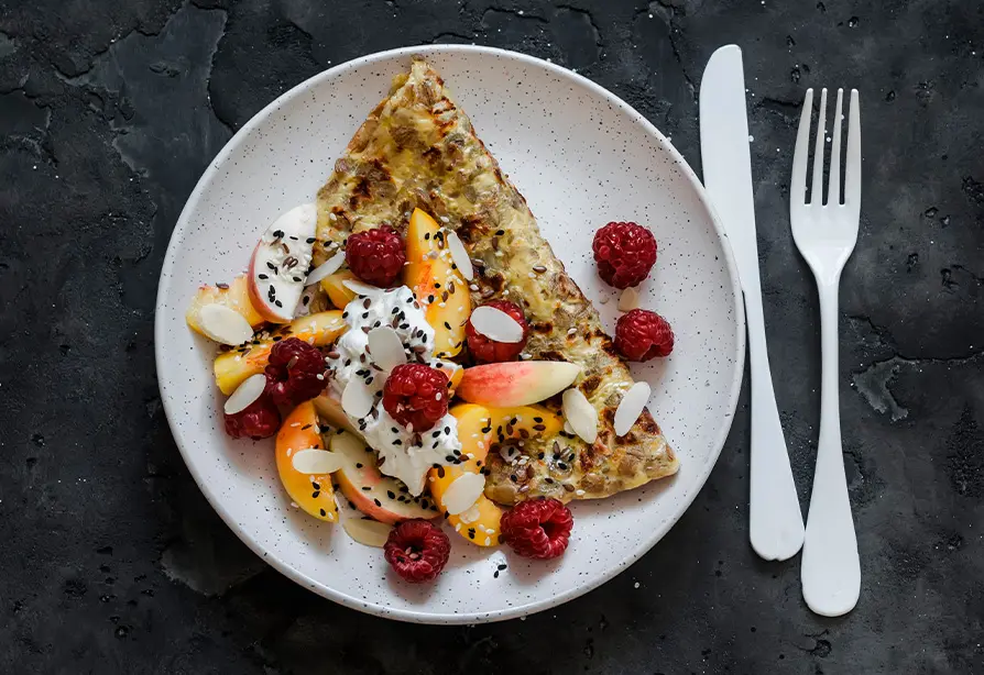 A plate with an omelette and fruits