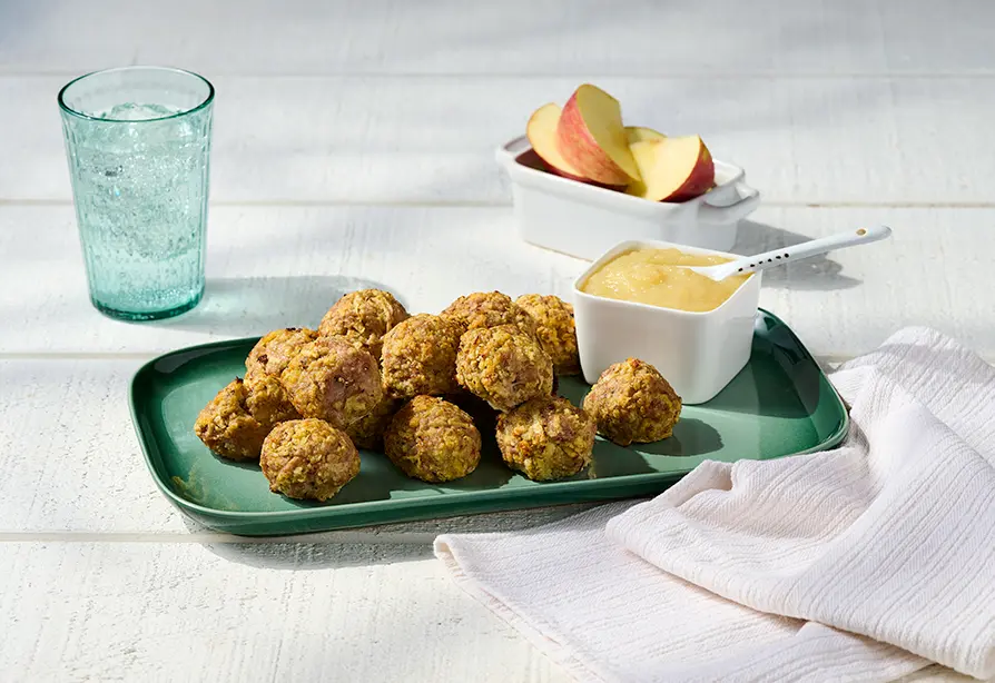 Turkey and apple meatballs on a plate with applesauce.